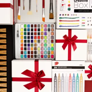Art supplies and gift boxes with red ribbons, including paintbrushes, markers, and a watercolor palette.