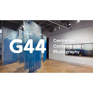 Art gallery space with blue hanging panels and framed photos, labeled 'G44 Centre for Contemporary Photography.