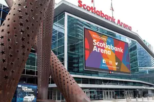 The exterior of Scotiabank Arena with a large digital welcome sign and modern metal sculpture in front.