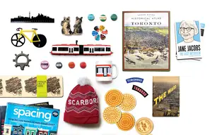 Assorted Toronto-themed souvenirs, including books, pins, postcards, a mug, a hat, and a streetcar toy.