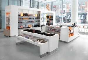 Modern gift shop with white shelves and tables displaying various merchandise and accessories.